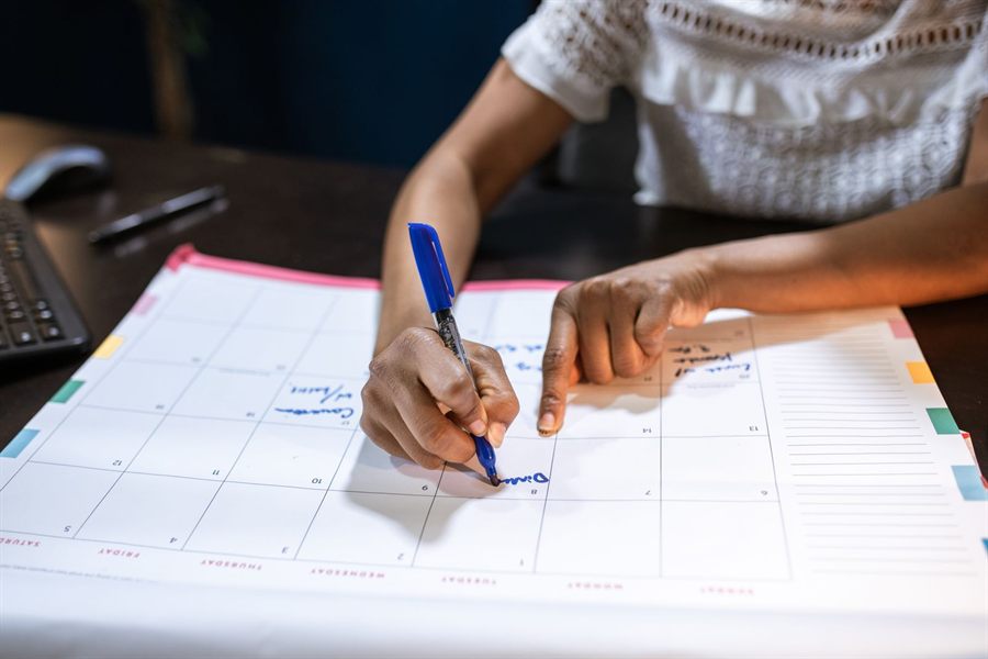 Woman marking dates on a desk calendar while planning