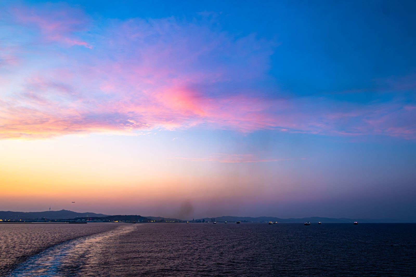 Sunset over the sea seen from the wake of a sailing ship, the kind of voyage the biggest cruise sales of the year promote